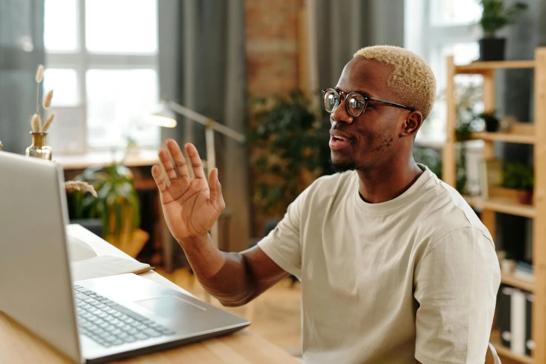 a man sits in front of a laptop on a table