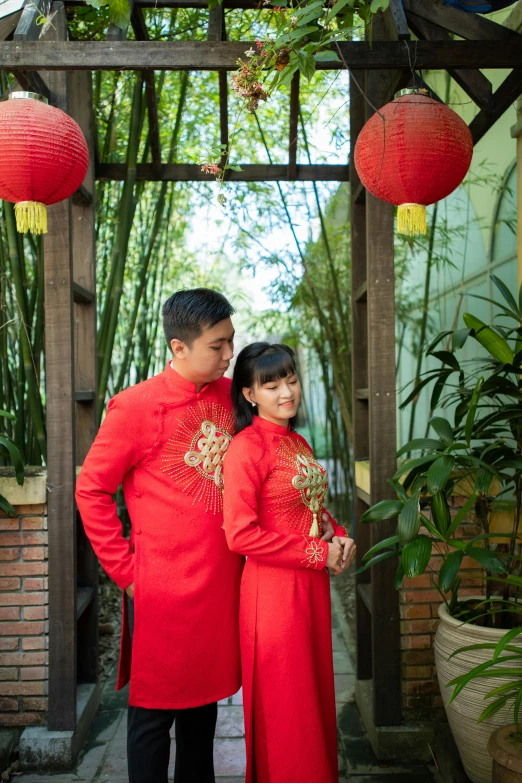 a couple in traditional chinese clothing posing for a picture