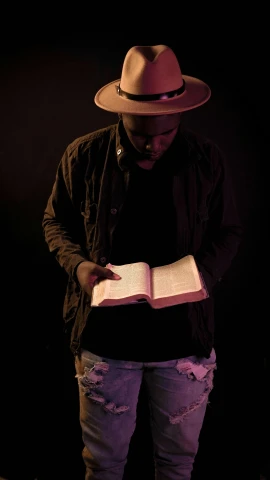 a man with a straw hat is reading a book