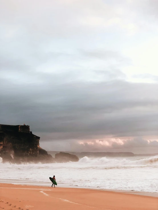 a person walking on a beach with waves