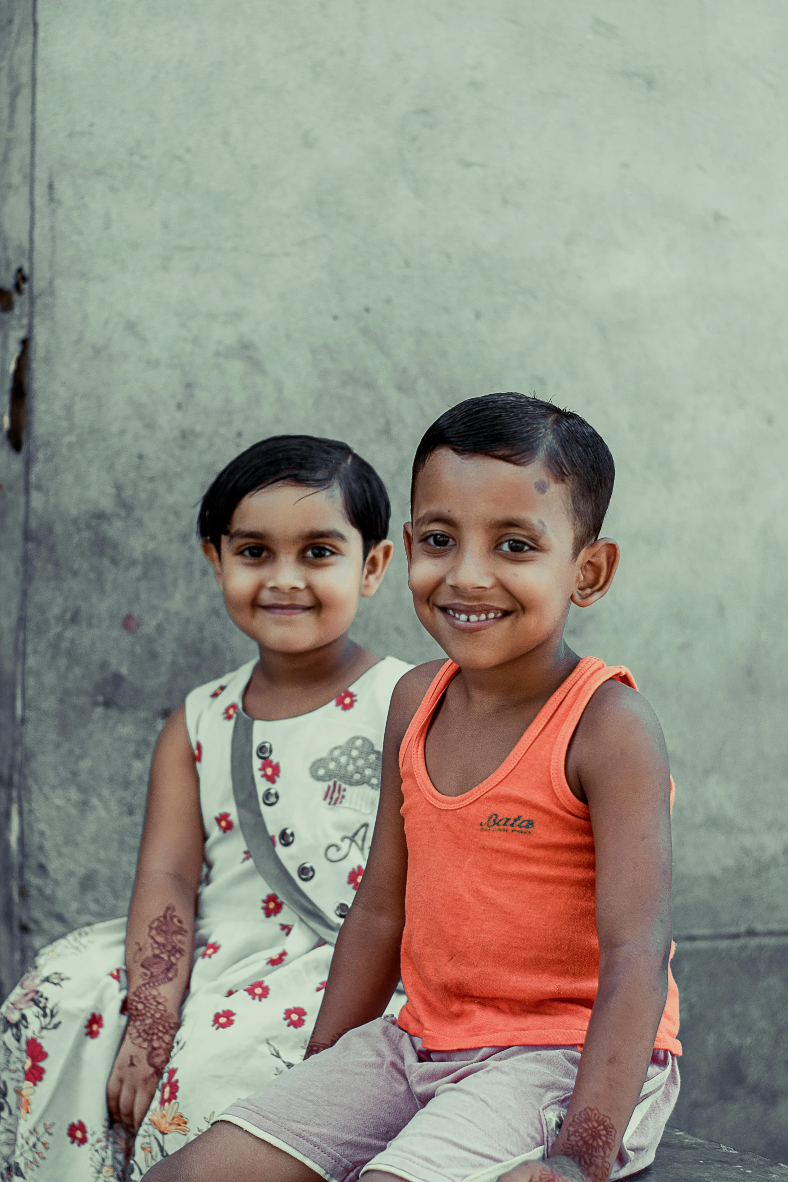 two young children sitting together smiling for a picture