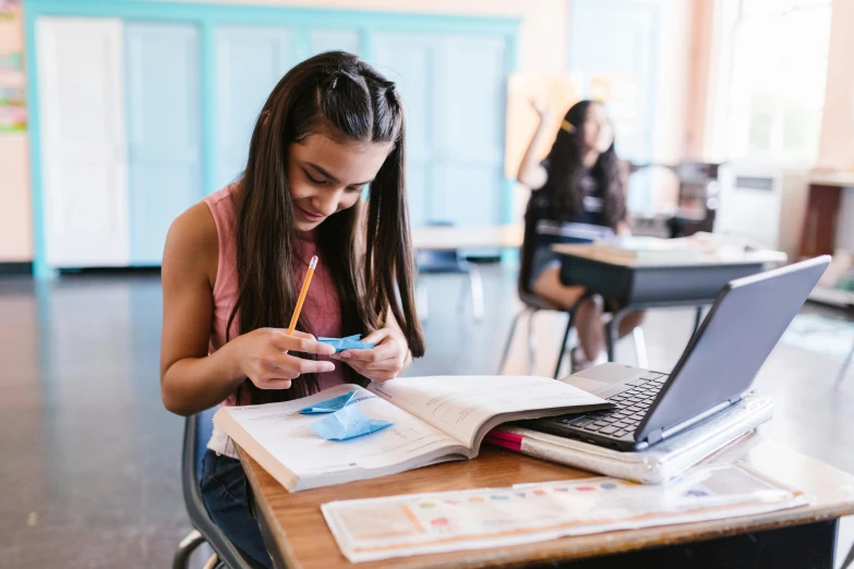 a woman is sitting at a desk and using her cell phone