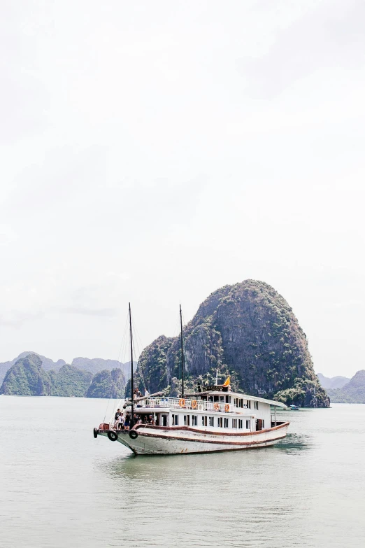 an old ship on a lake with islands in the background