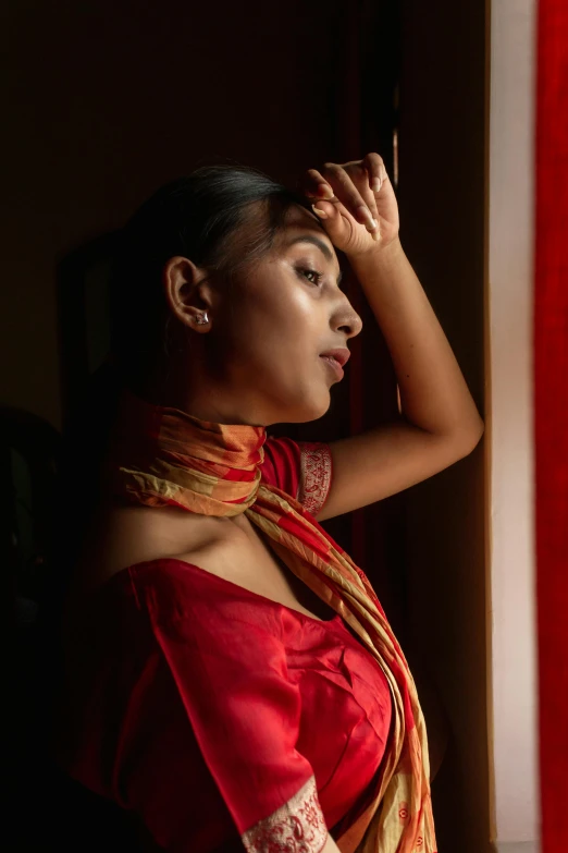 woman in red dress standing next to a red curtain