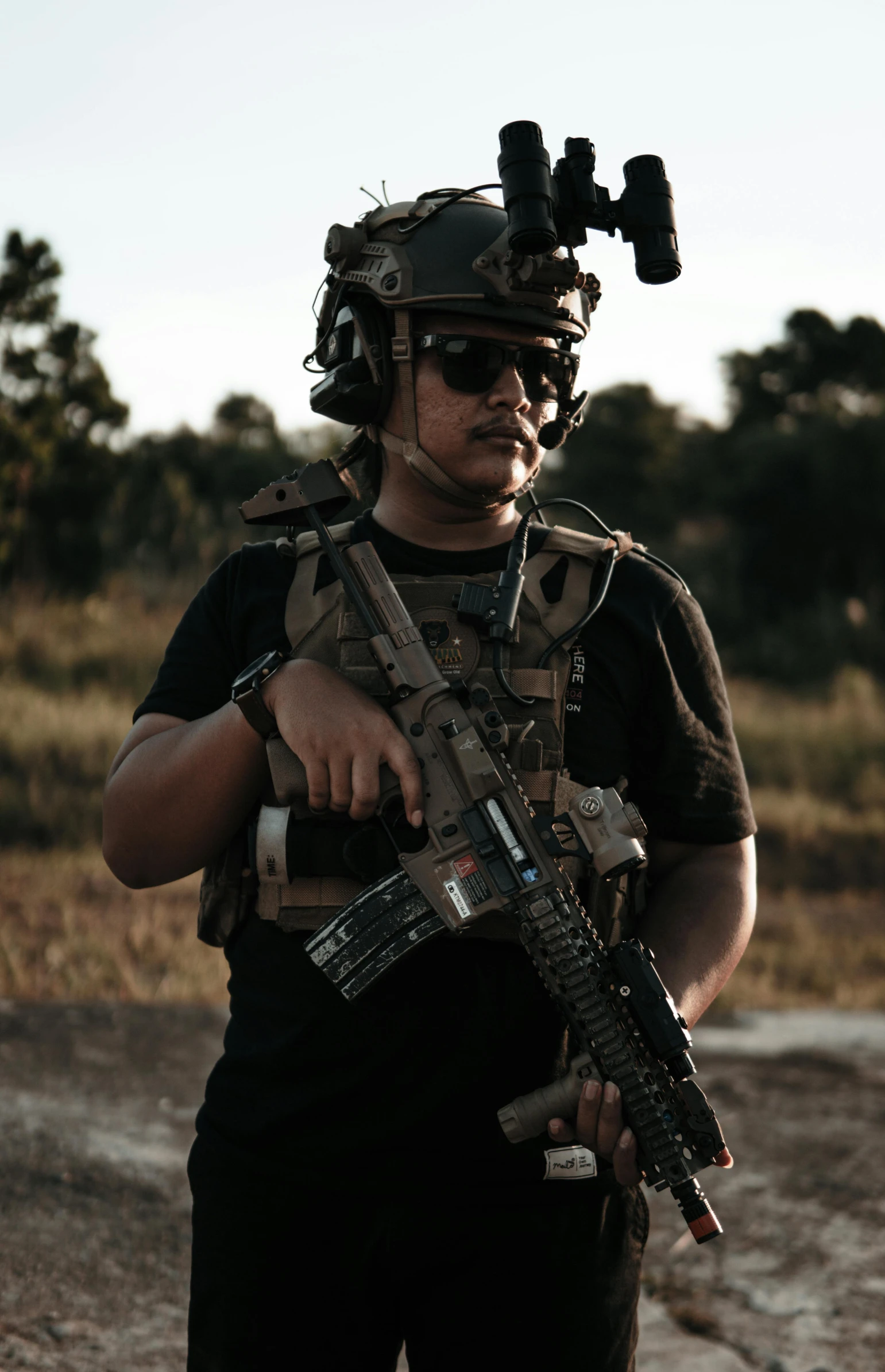 a man in camo holding a gun with one hand