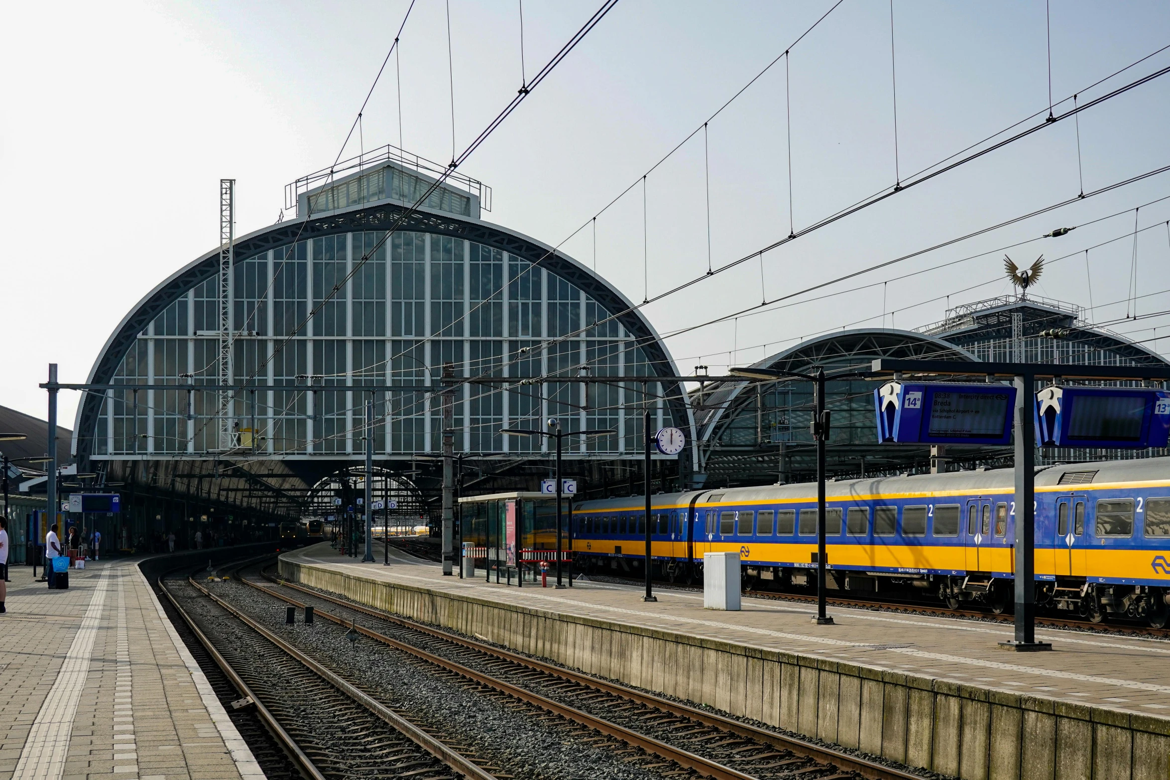 a train that is sitting on the tracks next to people