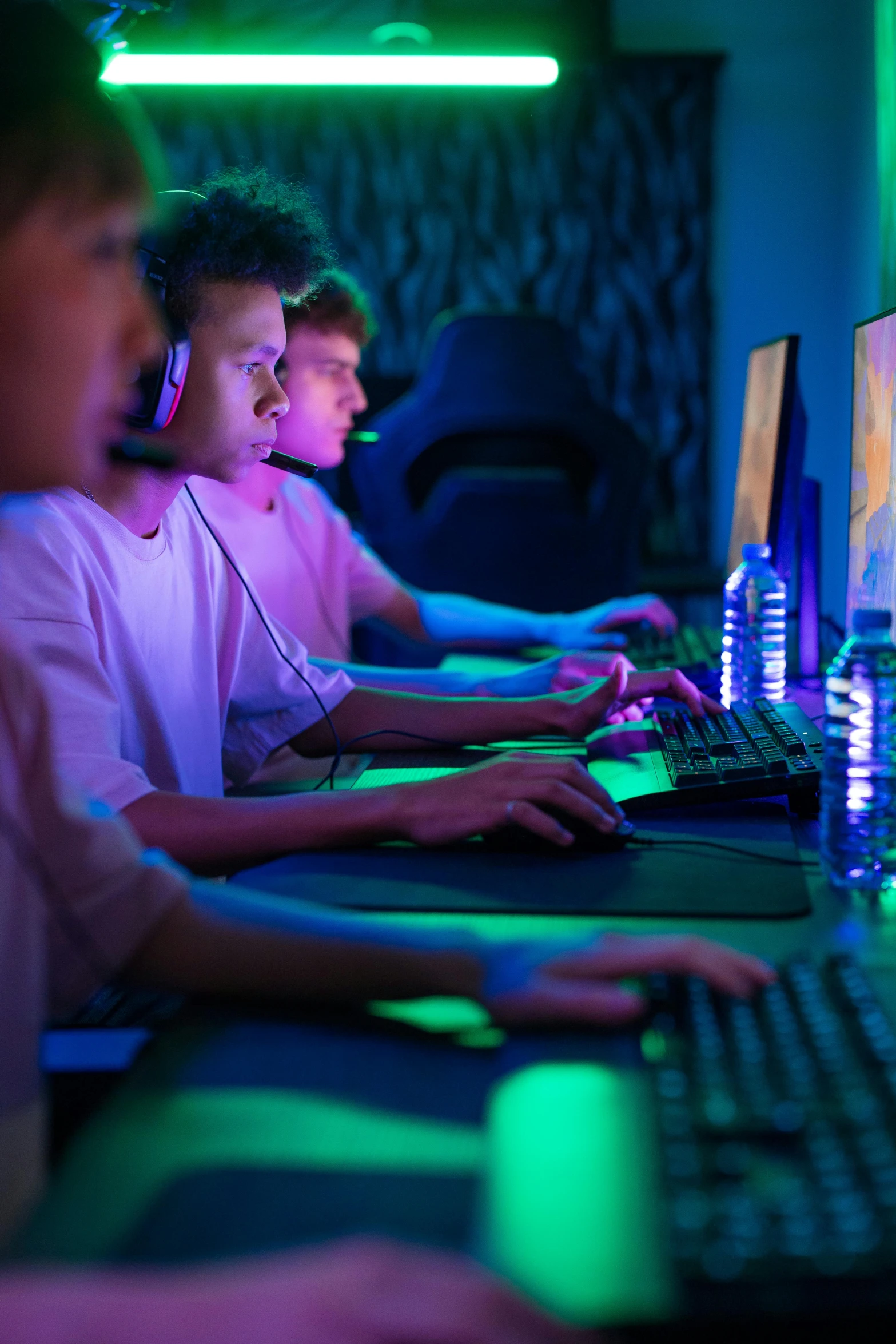 three boys using computers in the dark while working