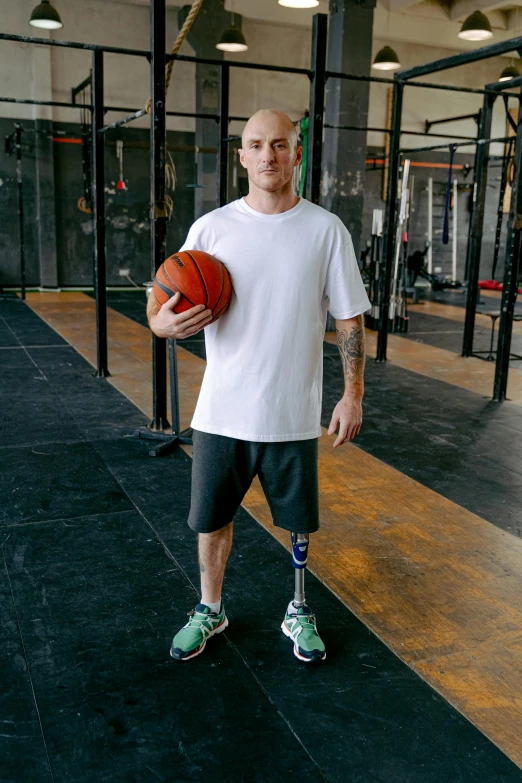 man holding basketball standing on a treadmill in a gym