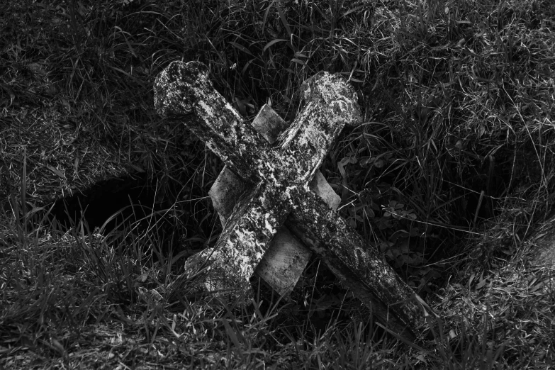 a large cross sits in the grass by itself