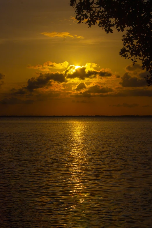 a sunset with clouds reflected on the water