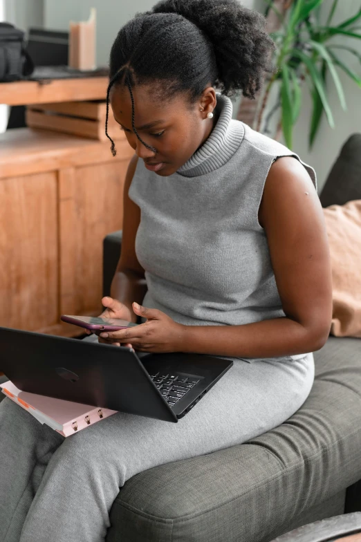 woman sitting on a couch in front of a computer