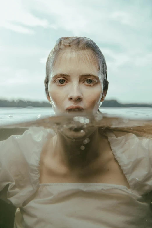 woman in white shirt with head under water