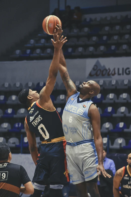 three players in uniform playing basketball on the court