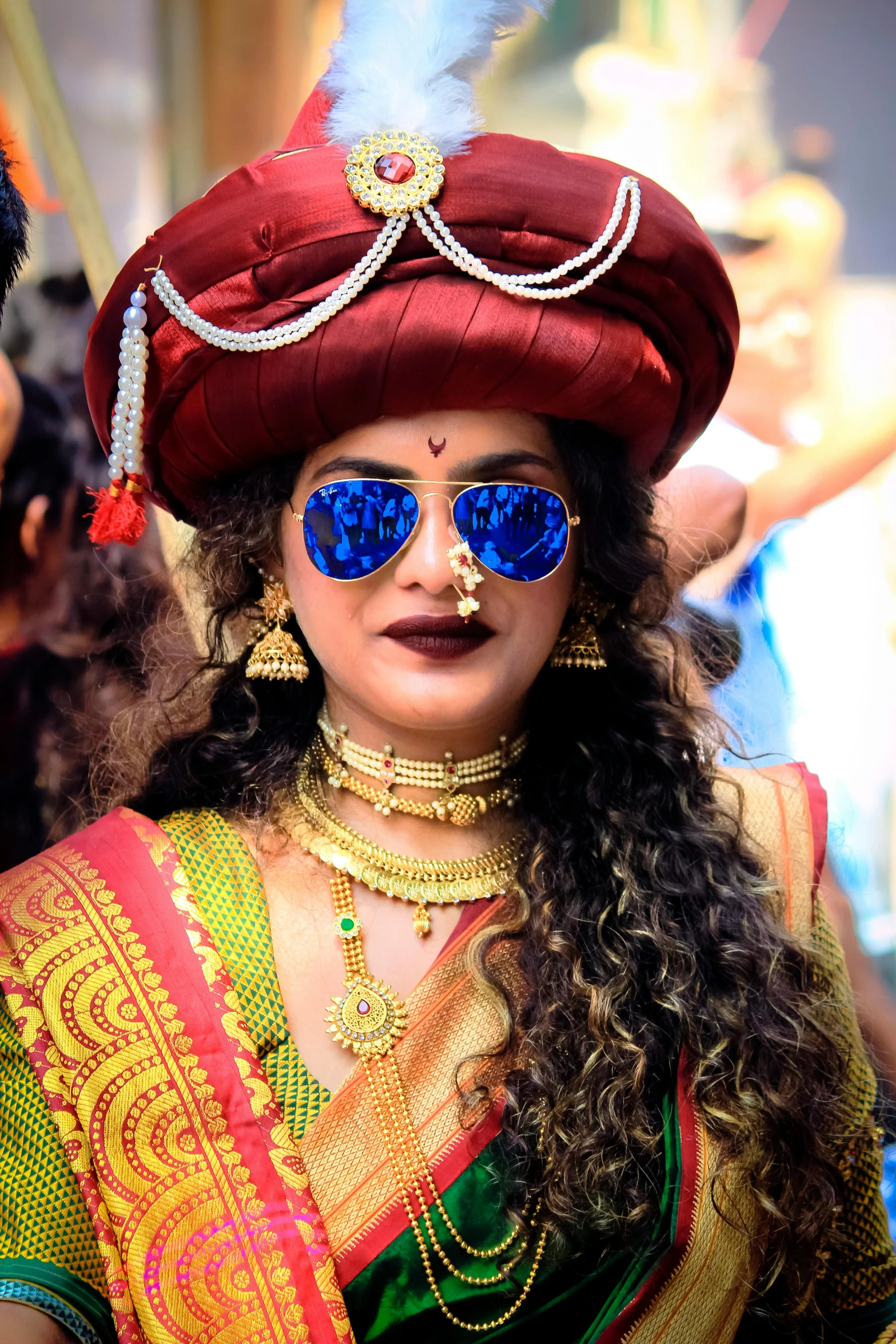 a woman wearing blue mirrored glasses and a red headdress