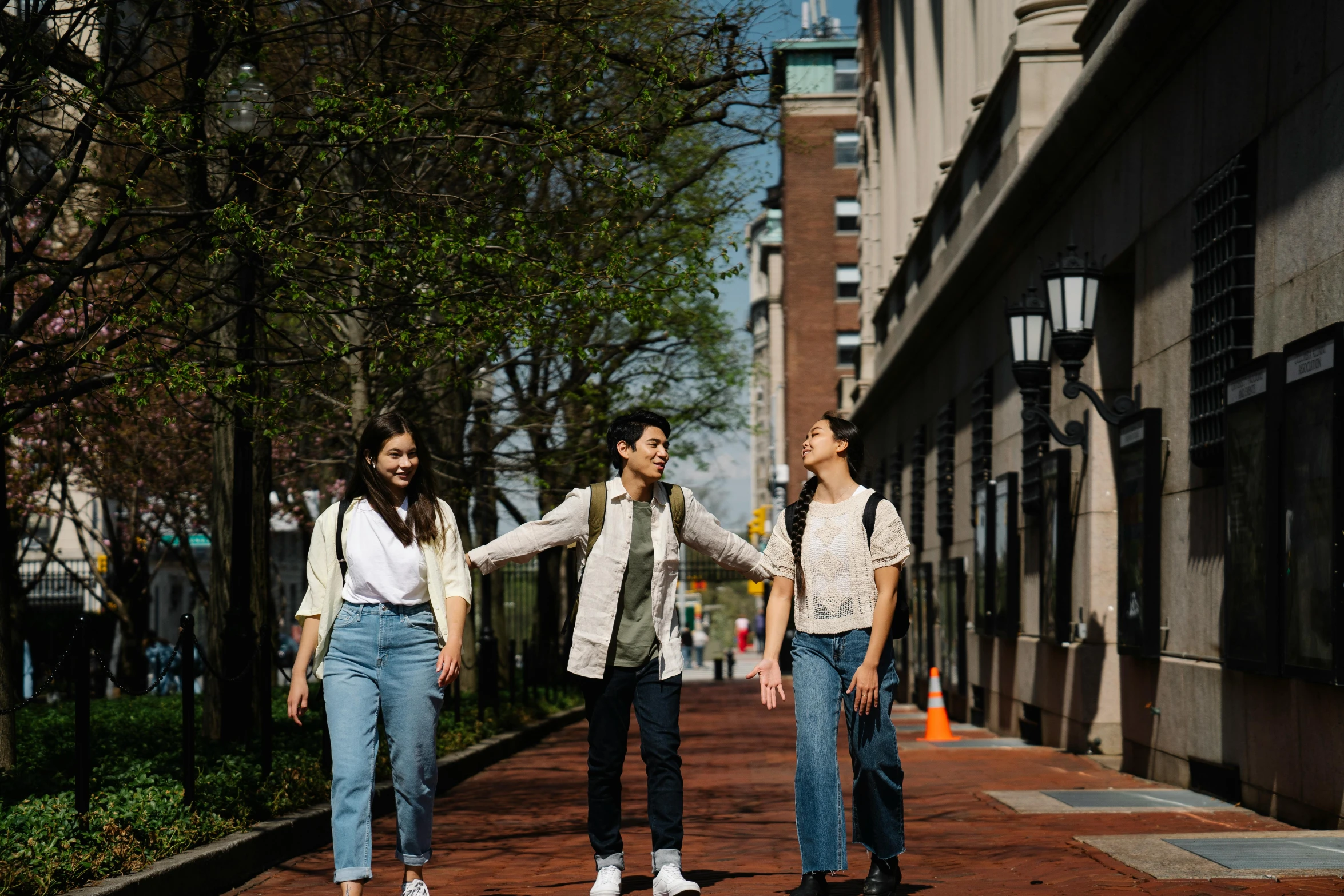 two girls are holding hands on a street