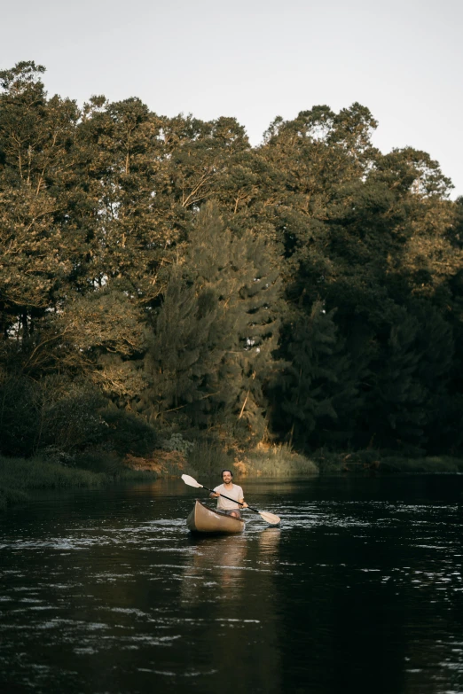 person in a canoe paddling down the river