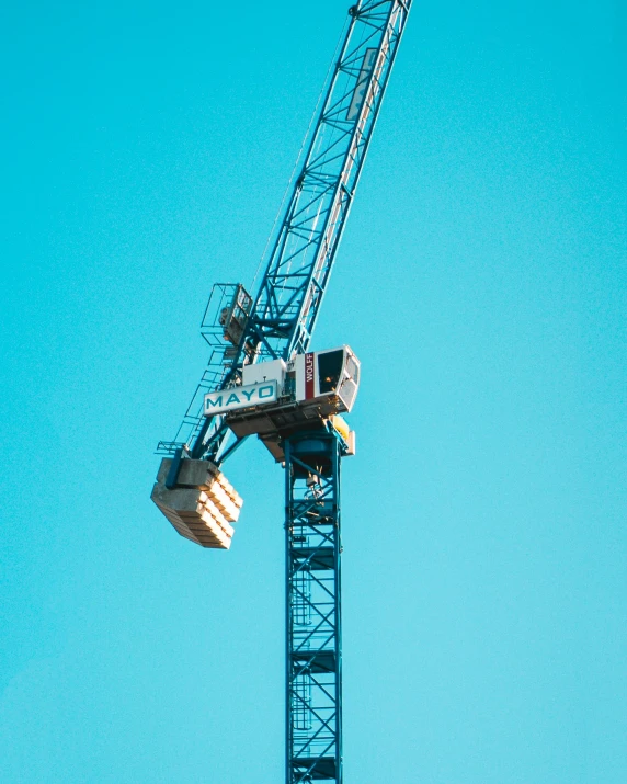 an industrial crane with no backhoes and blue skies