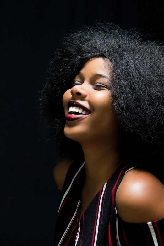 a girl with a large afro standing smiling