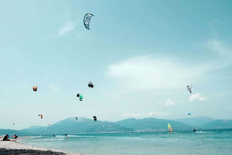 people flying kites on the beach on a sunny day