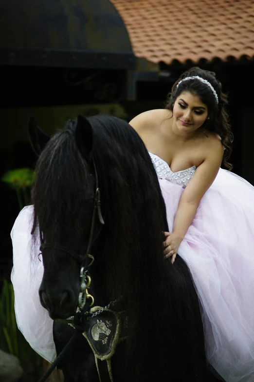 a beautiful woman in a dress sitting on the back of a horse