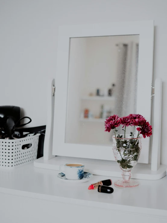 a mirror that has flowers in it on a table