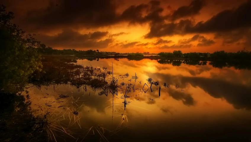 the sun sets over the calm water on a calm evening