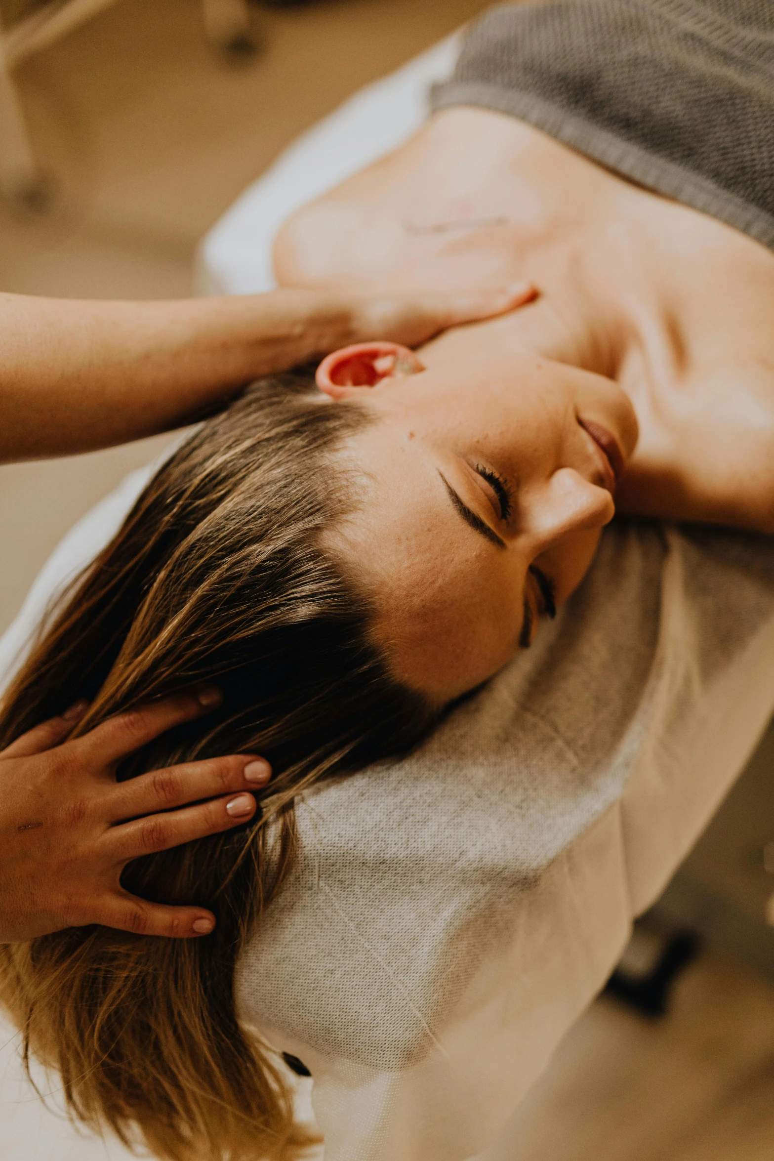 a lady receiving a facial massage from a drier