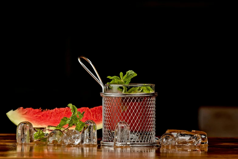 a glass and two pieces of fruit are set on a table