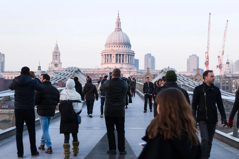 a group of people walking across a bridge