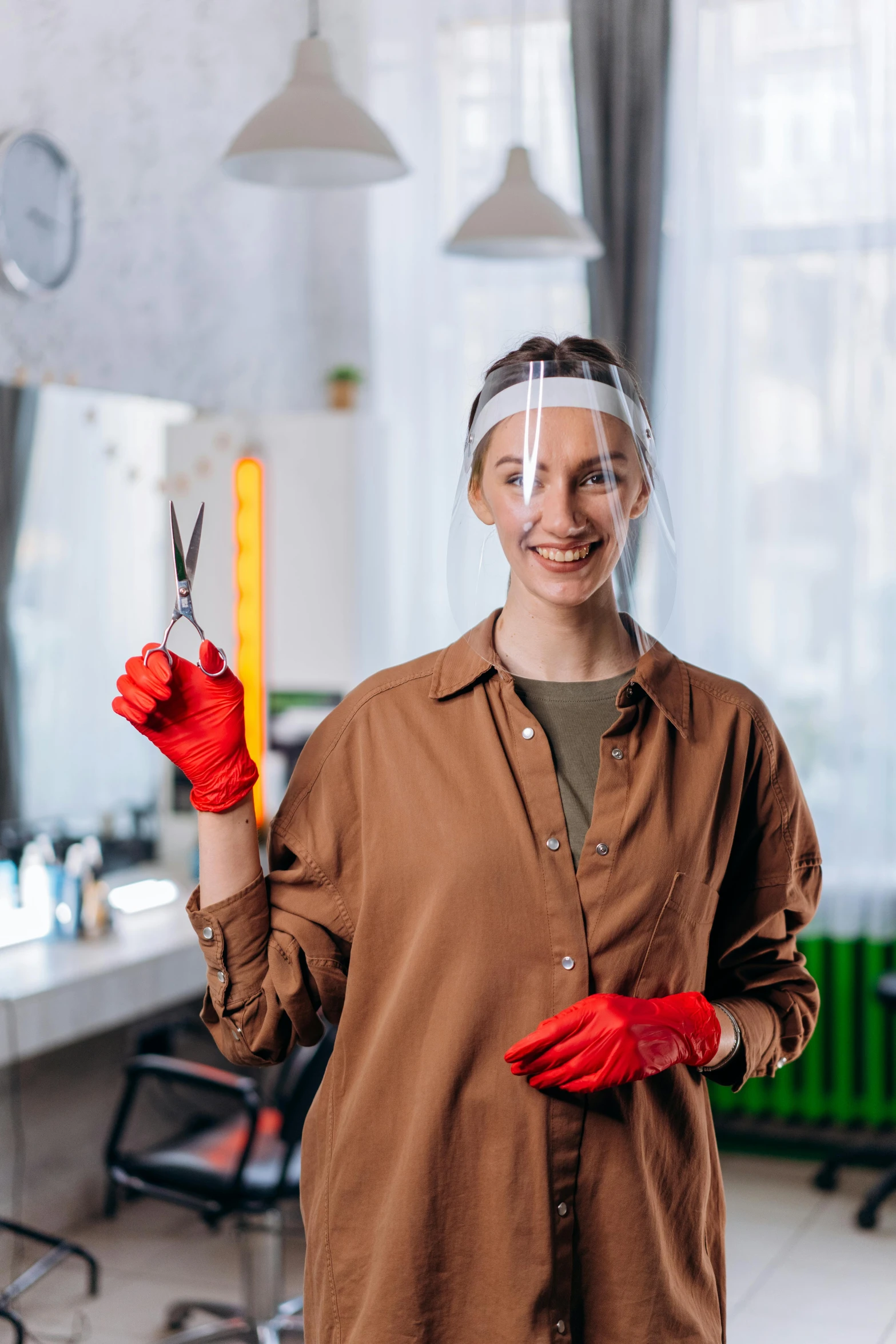 a person wearing safety gloves holding two pairs of scissors