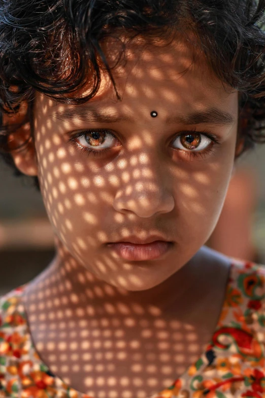 a young child with a sunlit background and a frilly