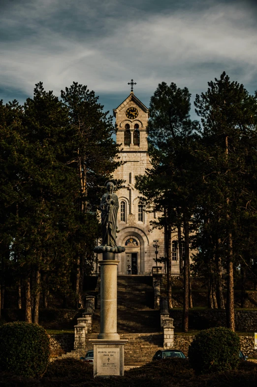 a tall building with a steeple sitting next to a forest