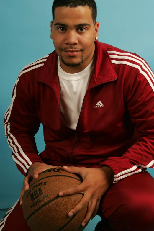 a man posing for a picture with a basketball