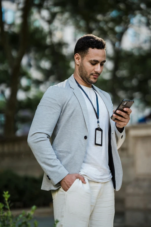 a man in a white outfit looking at his cell phone