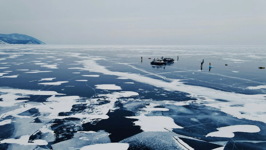 boats in the water covered in ice near a snowy shore