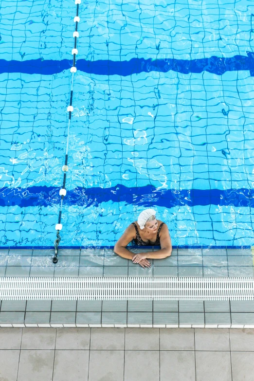 a woman leaning against the side of a pool