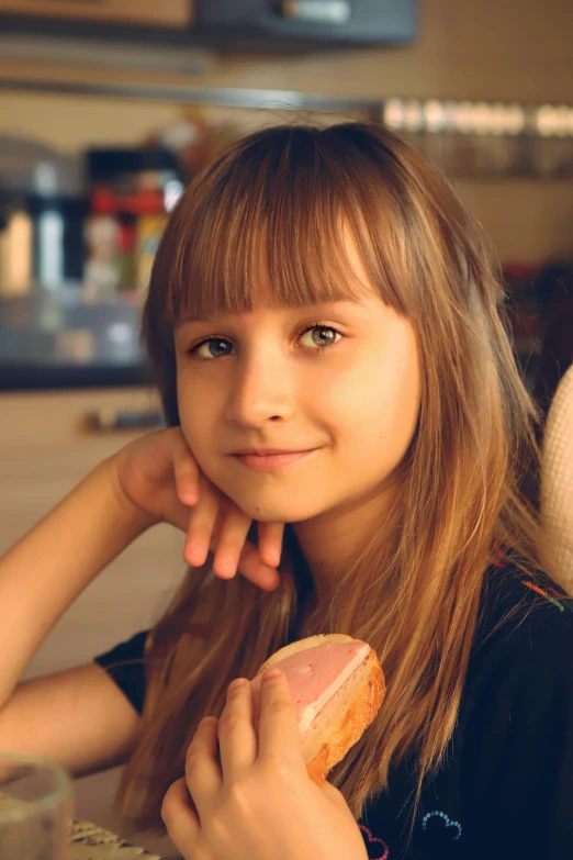 a girl eating a dog at a table