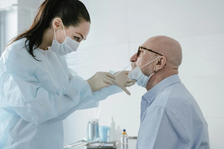 an older man in the hospital being assisted by nurse