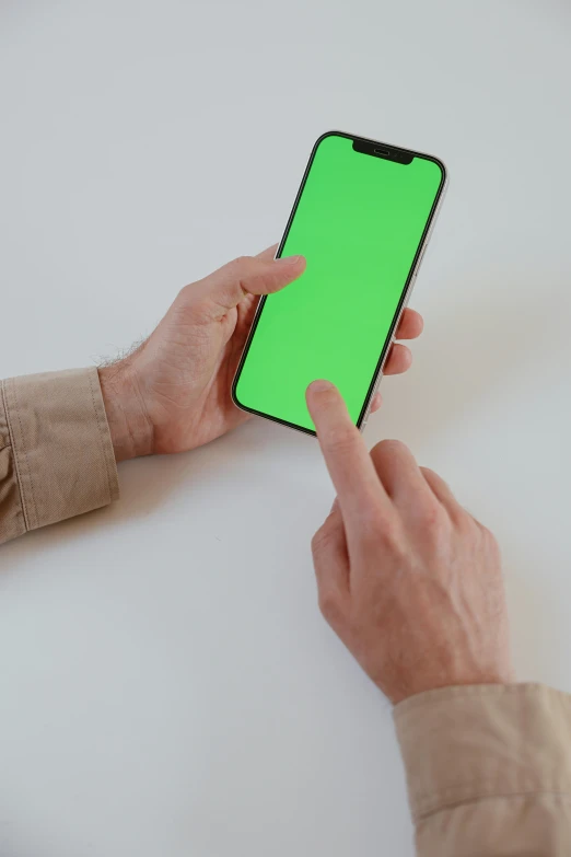 the man is holding a green cell phone