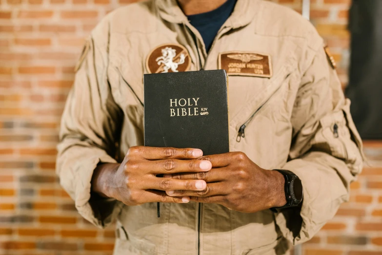 a man is holding a bible with the word jesus bible on it