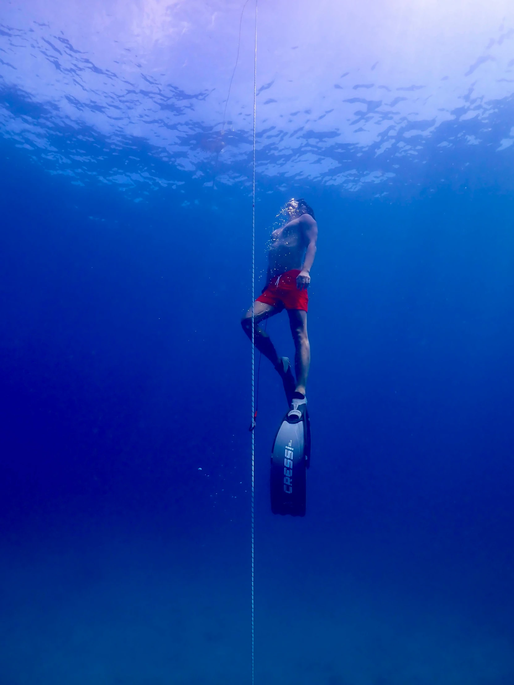 a man in red swim trunks is surfing on a pole