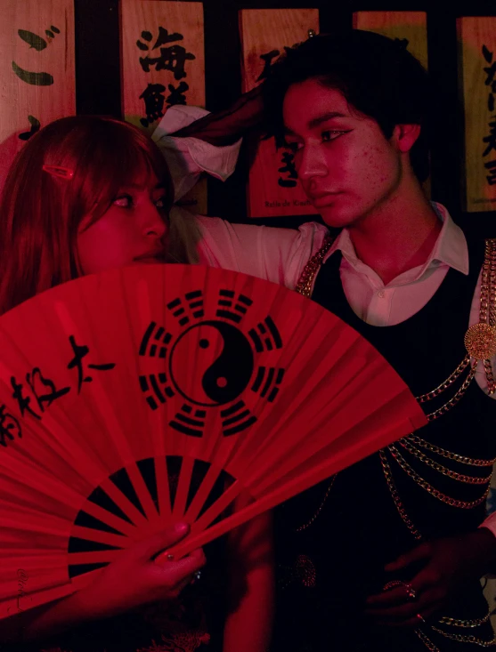 a man and woman holding a chinese umbrella