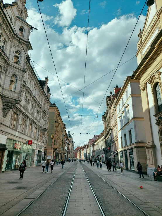 the street is lined with lots of buildings and people walking around