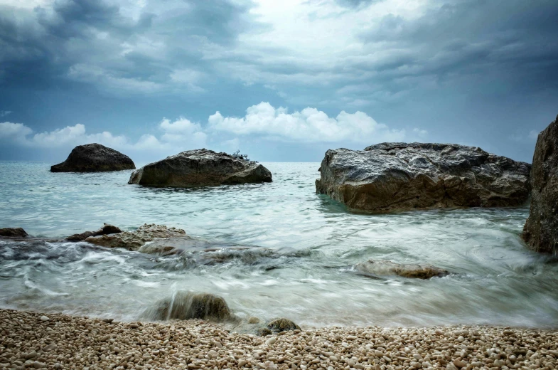 water surrounds some large rocks and looks like they are floating on the surface