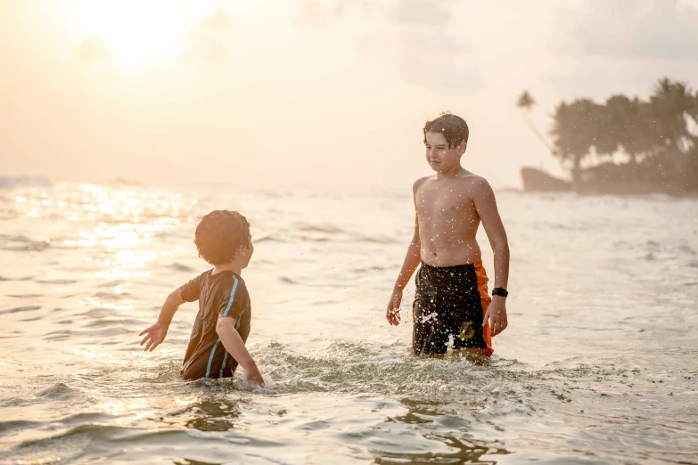 two children are playing in the ocean with a frisbee