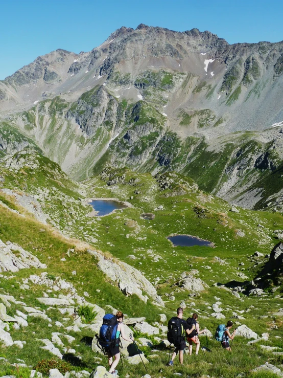 several people walking up some rocks in the mountains