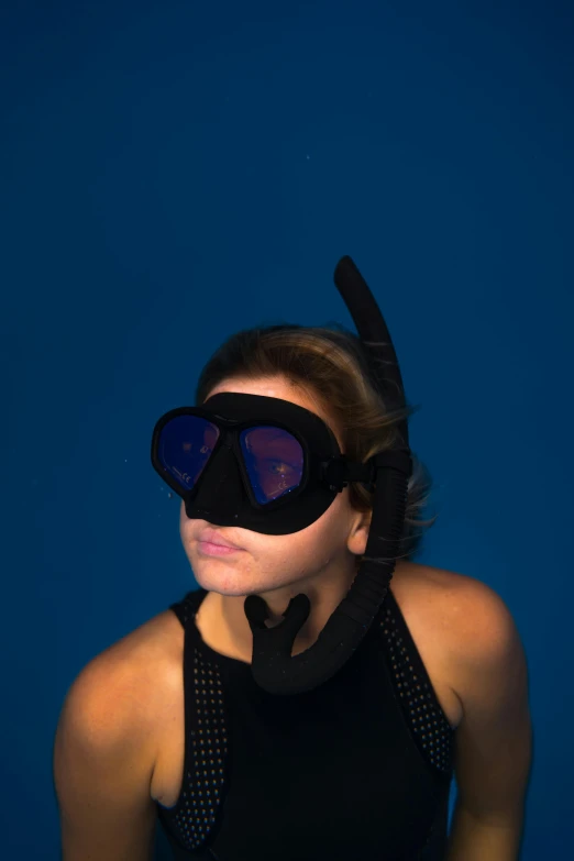 a woman with black hair wearing a diving mask and goggles