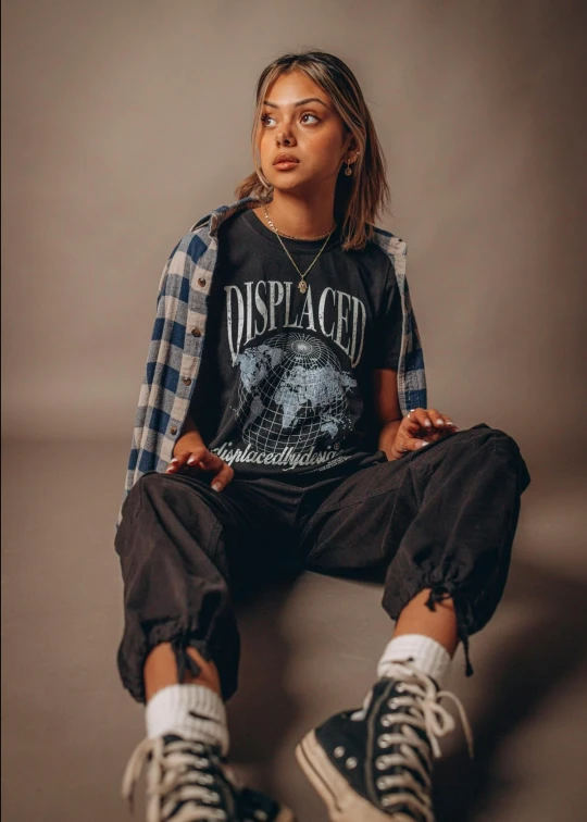 woman with ripped shorts and a t - shirt sitting on the floor