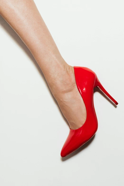 a woman's leg wearing red heels while standing