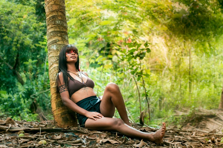 woman in native costume sitting in the forest